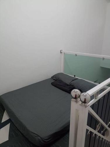ein kleines Bett in einem Zimmer mit Spiegel in der Unterkunft MinAn Homestay Gua Musang (no tv no wifi) in Gua Musang