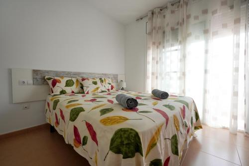 um quarto com uma cama com um edredão e almofadas em EBRE-SET em Sant Jaume d'Enveja