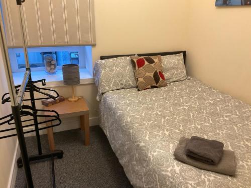 a bedroom with a bed and a table and a window at 103 Nelson Street 1 st floor Right in Largs