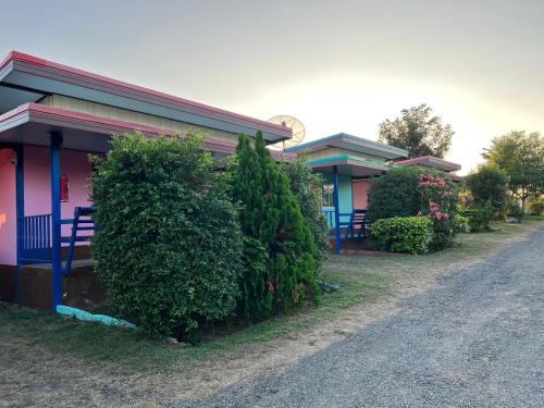 a row of houses with bushes next to a street at แป๊ะชวนชิมรีสอร์ท สาขา 2 in Sirindhorn
