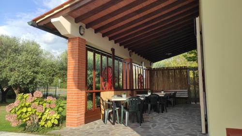a patio with black chairs and tables and awning at Gli Ulivi Rooms in Lucca