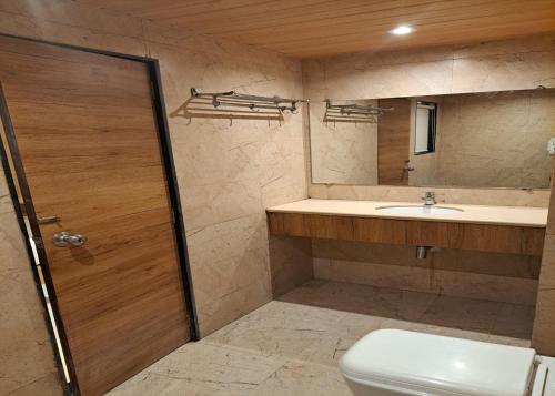 a bathroom with a toilet and a sink and a mirror at GATEWAY STAR HOTEL in Mumbai