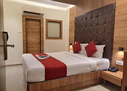 a bedroom with a large bed with red pillows at GATEWAY STAR HOTEL in Mumbai