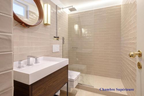 a bathroom with a sink and a toilet and a mirror at Hotel Boileau in Paris