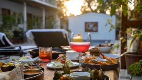 a table topped with plates of food and a drink at Whiteflower Cottages Vagator in Vagator