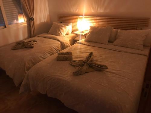 2 camas con arcos en una habitación de hotel en VISTA SUPERIOR hola ZEEZICHT!! en Cumbre del Sol