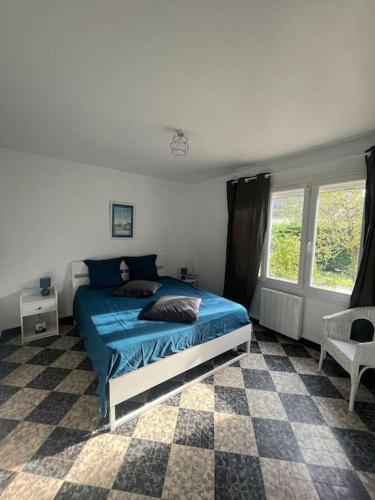 - une chambre avec un lit bleu et un sol en damier dans l'établissement Charmante Maison proche mer, à Colleville-Montgomery