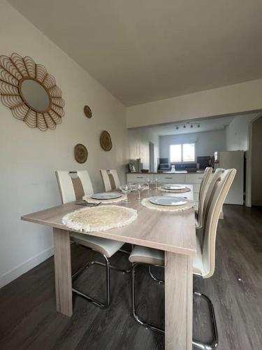 une salle à manger avec une table et des chaises dans l'établissement Charmante Maison proche mer, à Colleville-Montgomery