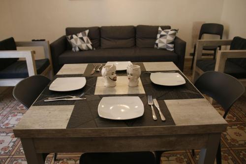 een tafel met borden en bestek erop bij Amira Apartments Trapani in Trapani