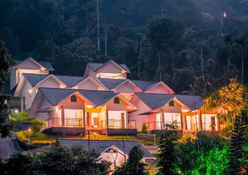 uma casa grande com luzes em cima em Munnar Majestic Resorts by VOYE HOMES em Anachal