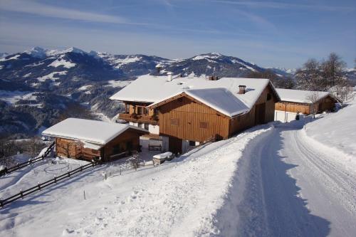 una casa en la cima de una montaña cubierta de nieve en Appartement Oberschernthann, en Hopfgarten im Brixental