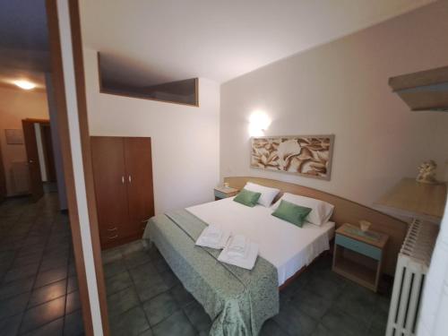 una camera da letto con un letto bianco con cuscini verdi di Depa Holidays a Lizzanello