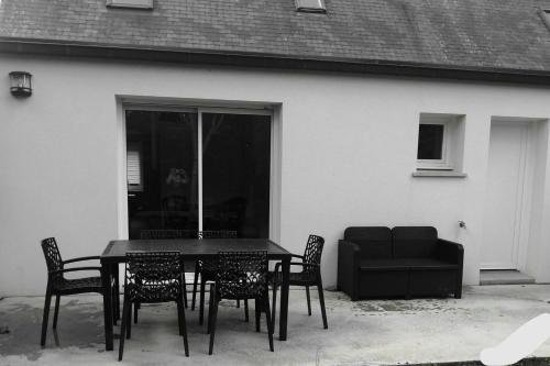 una mesa negra y sillas frente a una casa en Gite entre Paimpol et Erquy. Proche palais des congrès, en Ploufragan