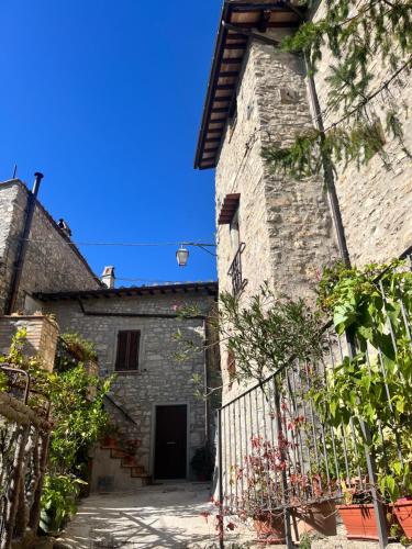 - une vue extérieure sur un bâtiment en pierre avec un portail dans l'établissement Appartamento a Valle San Martino di Spoleto, à Spolète