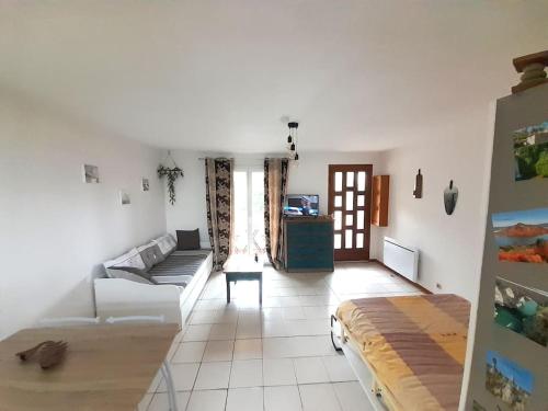 Le Cocouning في Ceyras: غرفة معيشة بها أريكة وطاولة