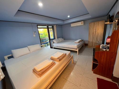 a room with a bed with two towels on it at แป๊ะชวนชิมรีสอร์ท สาขา 2 in Sirindhorn