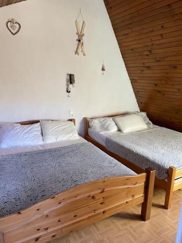 - une chambre avec 2 lits et une horloge murale dans l'établissement Chalet cosy-vue sur la montagne & montgolfières, à Saillagouse