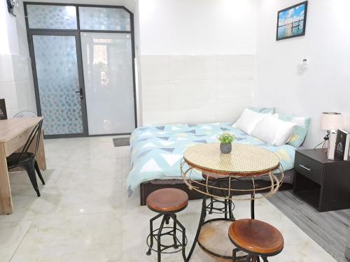 a bedroom with a bed and a table and stools at Cozy studio at Hai Ba Trung st., Dist 3 near Tan Dinh market in Ho Chi Minh City