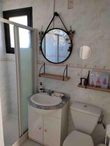 une salle de bain avec un lavabo, des toilettes et un miroir dans l'établissement Chalet cosy-vue sur la montagne & montgolfières, à Saillagouse