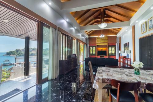 a dining room with a table and a view of the ocean at Villa Serenity pool SeaView 6BR in Kamala Beach