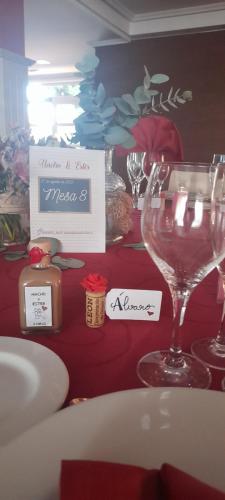 un tavolo con bicchieri da vino e un cartello sopra di Hotel Las Moreras a León