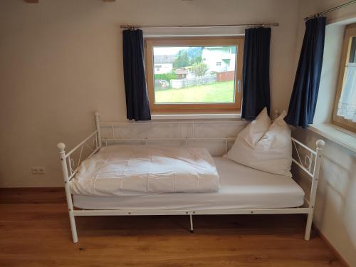 a white bed in a room with a window at Villa Mountainview in Bludenz
