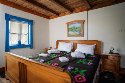 a bedroom with a wooden bed with flowers on it at Eko Zaseok Brana in Rekovac