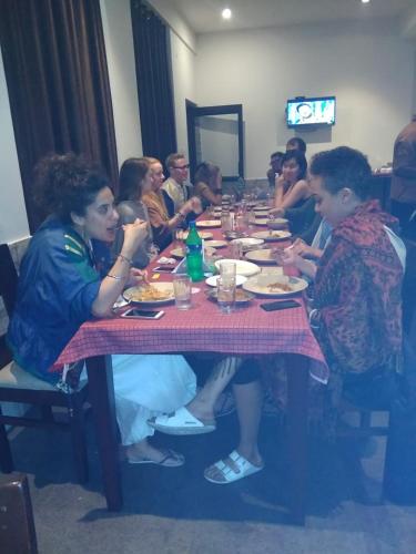 een groep mensen die aan een tafel eten bij HOTEL OM SHIVAAY INN in Rishīkesh