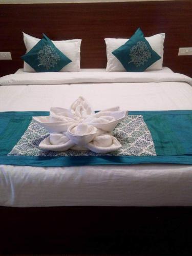 een witte bloem in een kom op een bed bij HOTEL OM SHIVAAY INN in Rishīkesh