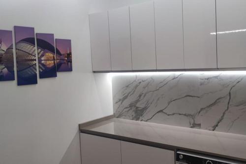 a kitchen with white cabinets and marble counter tops at Apartamento 4 habitaciones 2 baños Ciudad de las Ciencias VT-55209-V in Valencia