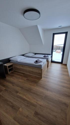1 dormitorio con cama y ventana grande en Luxusní apartmány Čerťák en Vaclavov u Bruntalu