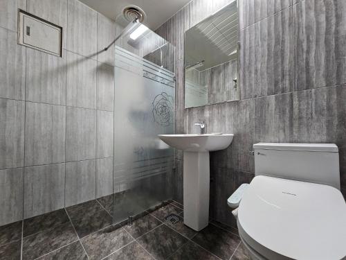 a bathroom with a toilet and a sink and a mirror at HOTEL ViA in Ansan