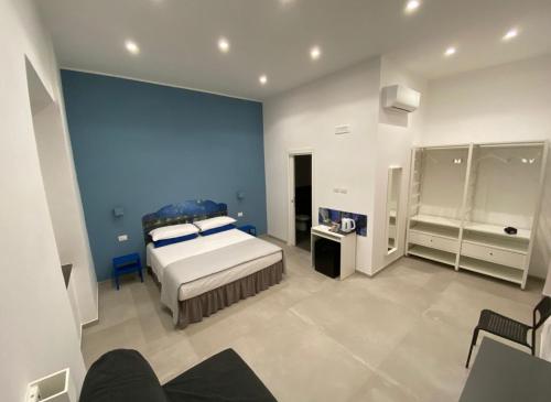 a bedroom with a bed and a blue wall at Partenope 10 in Naples