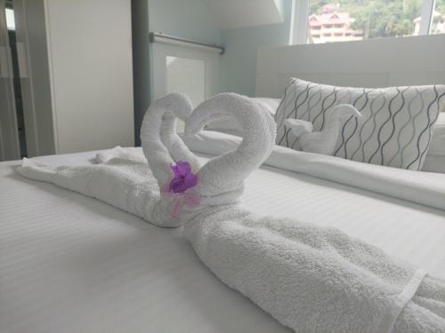 two towels shaped like swans sitting on a bed at Reef Hills Residence LUXURY VILLA in Anse aux Pins