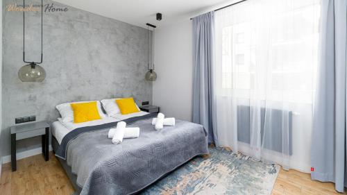 a bedroom with a bed with yellow and white pillows at Wonder Home - Apartament Dolce Vita blisko tras rowerowych Single Track i kolei gondolowej in Świeradów-Zdrój