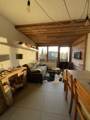 un salon avec un canapé et une table dans l'établissement Le repère de Bianca, le premier de cordée, à Montgenèvre