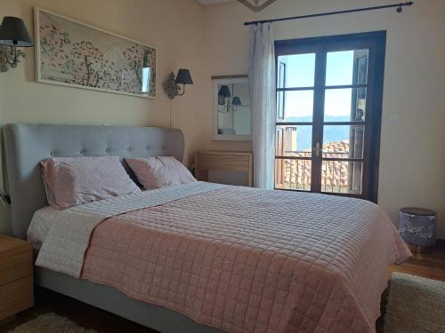 阿拉霍瓦的住宿－Ilias home Arachova，一间卧室设有一张床和一个美景窗户。