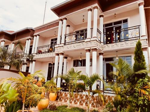 Kigali Peace villa في كيغالي: بيت أبيض كبير مع شرفة
