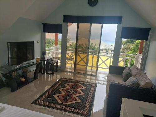 a living room with a couch and a view of the ocean at Reef Hills Residence LUXURY VILLA in Anse aux Pins
