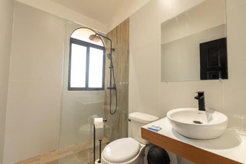 a white bathroom with a sink and a shower at Flat Anchor Marine Monte Vista in Sosúa