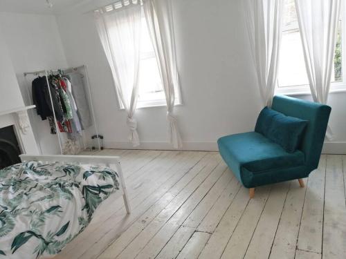 a living room with a couch and a chair at Seaside 2 bed terraced house with garden in Hastings