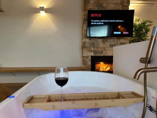 a glass of wine sitting in a bath tub with a wine glass at KAUKABA-Apartamentos Rurales- Adults Only in Pozo Alcón