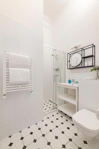 a white bathroom with a toilet and a shower at Beletage-Boutique Hotel in Budapest