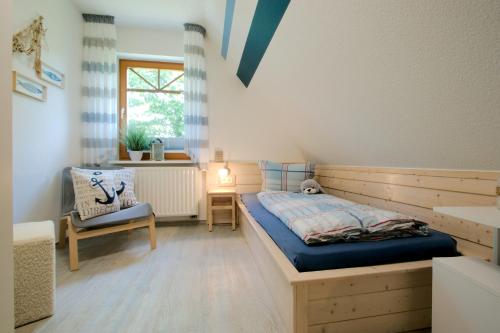 シュタインフーデにあるFerienhaus Juleの小さなベッドルーム(ベッド1台、椅子付)