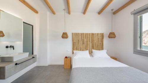 a bedroom with a bed and a sink at Agia Kyriaki Studios in Agia Kiriaki Beach