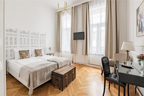 House Beletage-Boutique في بودابست: غرفة نوم بيضاء بسرير ومكتب وكرسي