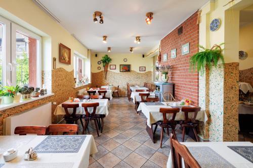 un restaurante con mesas y sillas y una pared de ladrillo en Dom Gościnny Relax, en Rewal