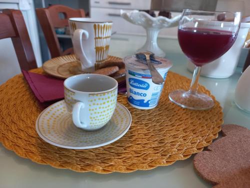 een tafel met een koffiekopje en een glas wijn bij A un passo da... B&B in Elmas