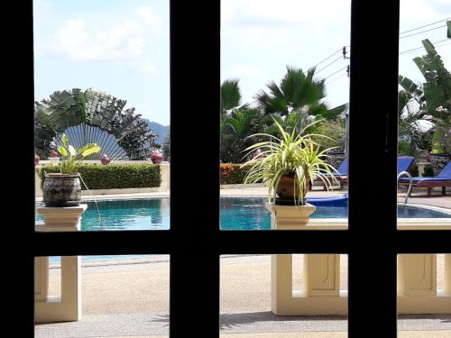 a view of a pool through a window at Prince Edouard Apartments & Resort Patong Beach Phuket in Patong Beach
