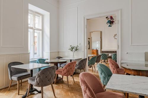 House Beletage-Boutique في بودابست: غرفة بها طاولات وكراسي ومرآة